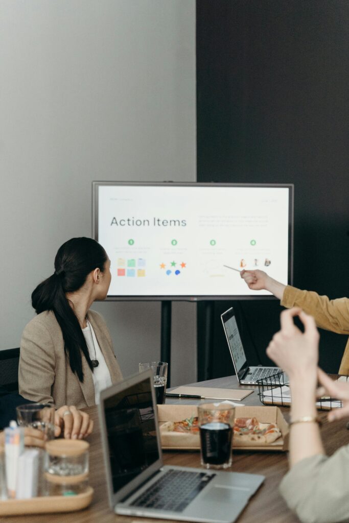 Colleagues discussing a presentation of action items in an office setting.